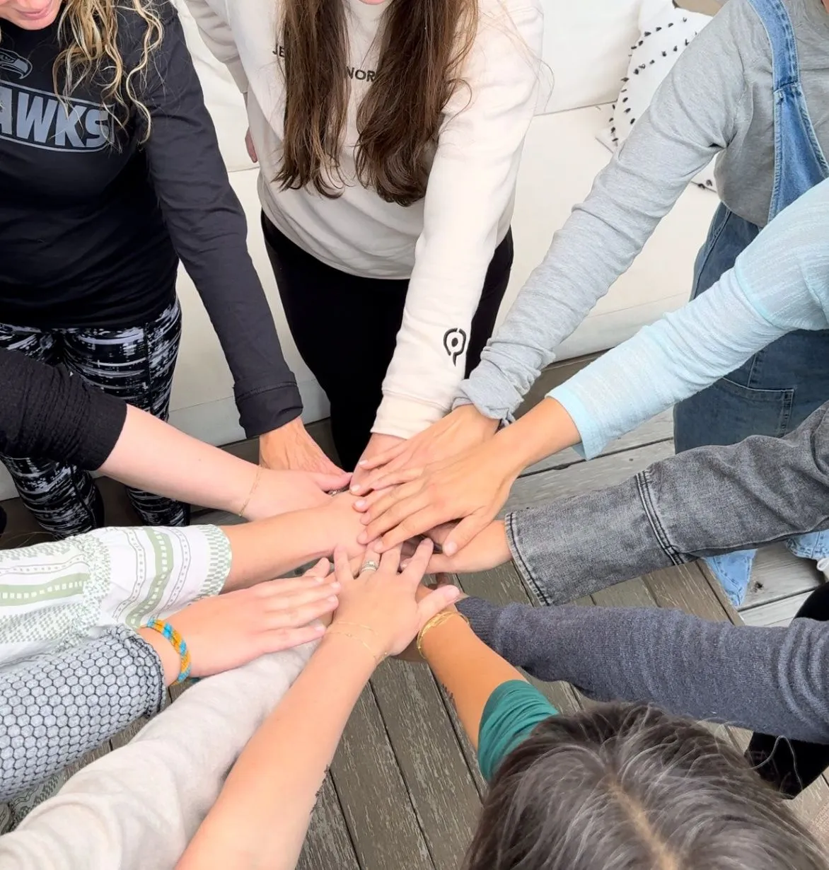 Women joining hands together in prayer